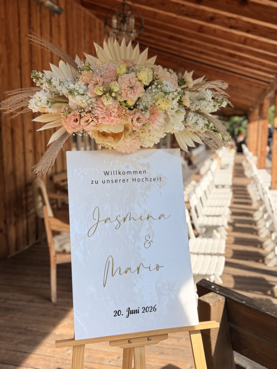Florales Willkommensschild zur Hochzeit mit Pfirsich- und Trockenblumengesteck